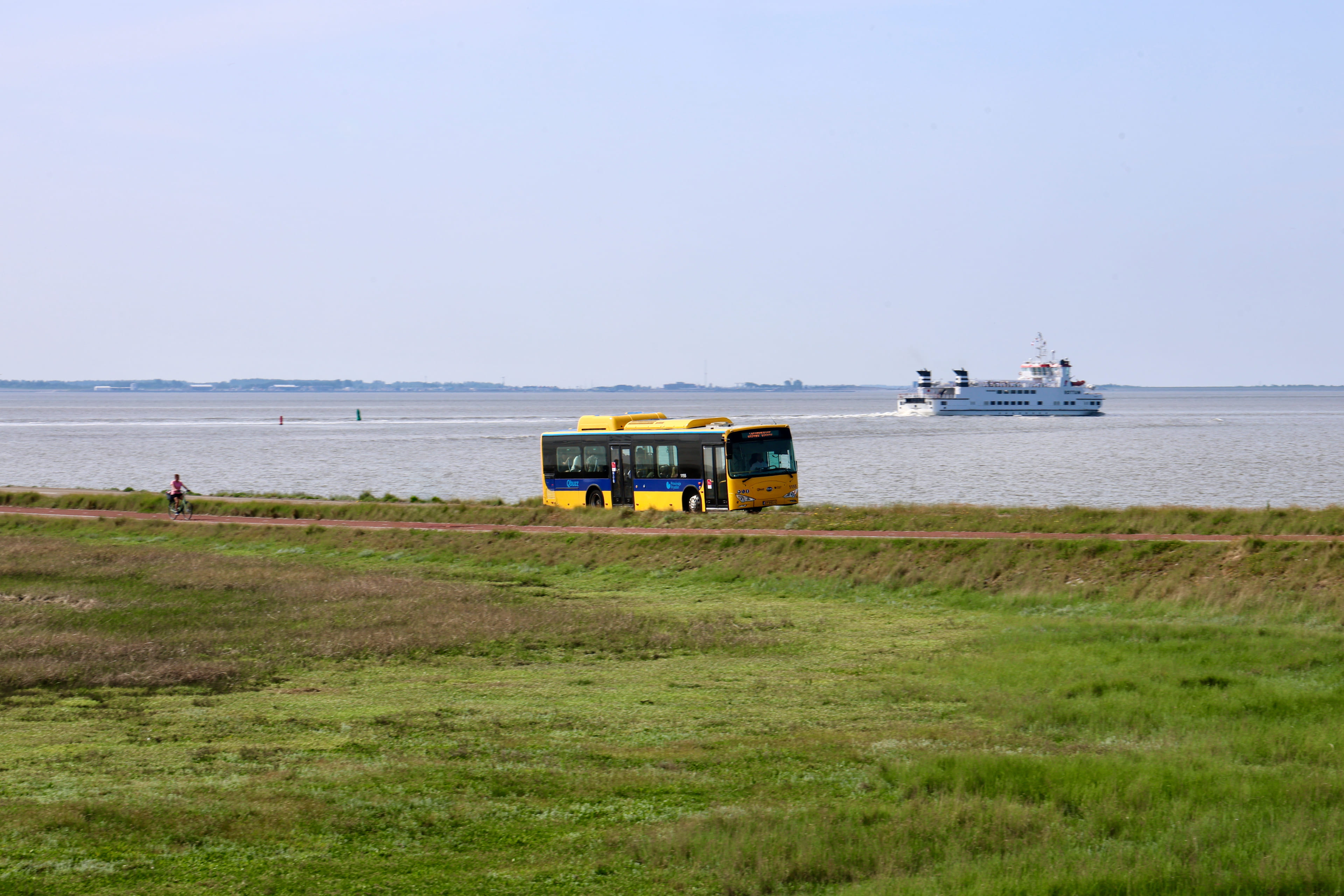 Bus rijdt langs het water in Friesland